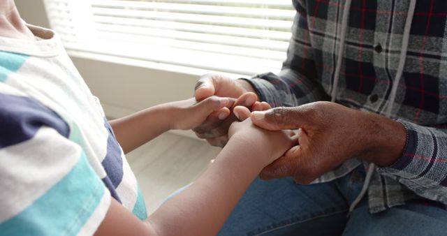 Holding hands of african american grandfather and grandson at home - Download Free Stock Photos Pikwizard.com