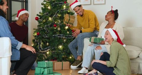 Joyful Friends Celebrating Christmas Exchange Gifts by Tree