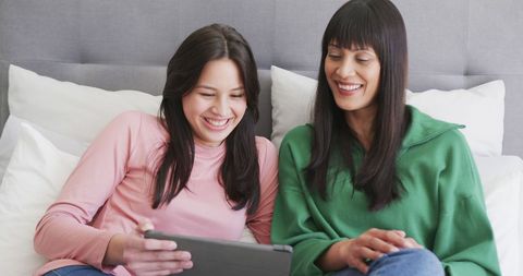 Mother and Daughter Bonding Using Tablet on Bed