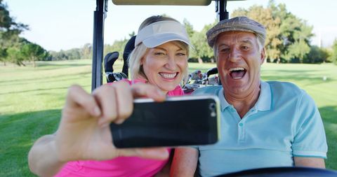 Smiling golfers taking selfie at golf course