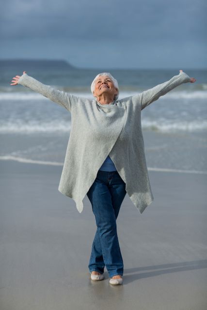 Senior woman doing stretching exercise on the beach - Download Free Stock Photos Pikwizard.com