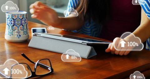 Woman Using Digital Tablet with Cloud Technology Icons in Office