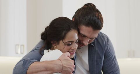 Couple smiling during wedding preparations in cozy home setting