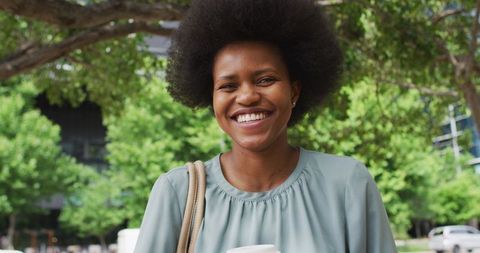Smiling African American Businesswoman with Coffee in Urban Park