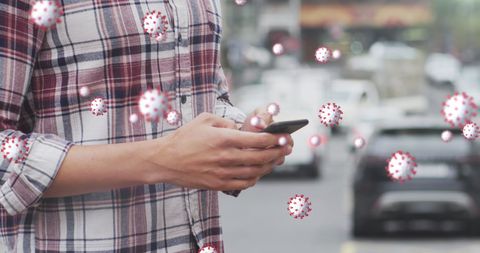 Man Using Smartphone Surrounded by Floating Viruses on Urban Street