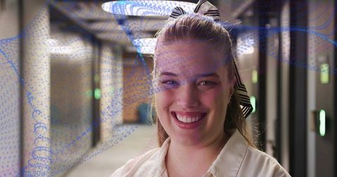 Smiling woman in futuristic corridor with led panels