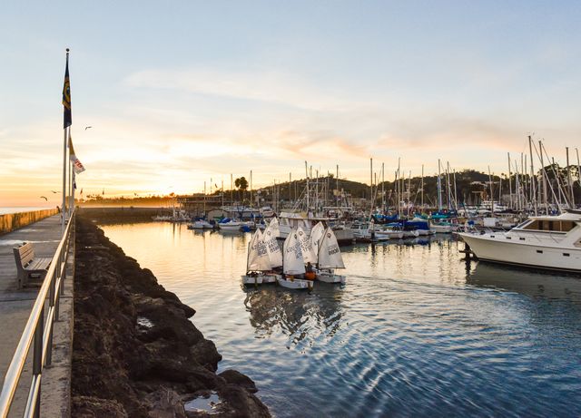 Tranquil sunset scene with harbor full of sailing boats and yachts reflecting in water. Ideal for travel blogs, marine-themed promotions, and destination marketing. Captures peaceful and serene atmosphere suitable for tourism advertisements.