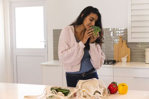 Woman Savoring Organic Produce in Modern Kitchen