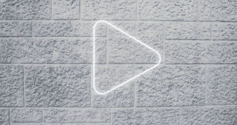 Neon Arrow Icon on Brick Wall Signifying Digital Interface