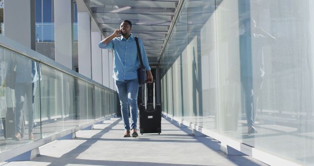 Image of african american man walking with suitcase and using smartphone - Download Free Stock Photos Pikwizard.com
