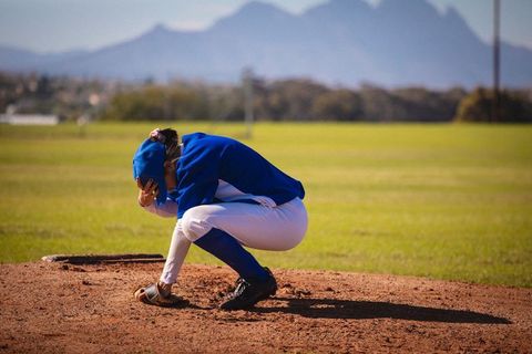 Journey of a young athlete: teen girl in deep reflection on baseball field
