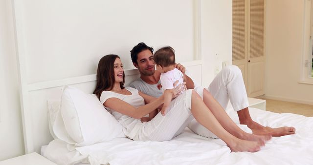 Happy Young Family Playing with Baby on Cozy Bed - Download Free Stock Images Pikwizard.com