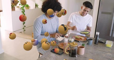 Two friends making avocado toast at modern kitchen island with floating emoji reactions