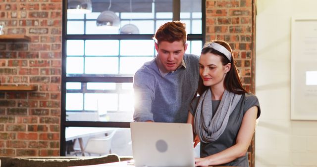 Coworkers Collaborating on Laptop in Modern Office with Exposed Brick - Download Free Stock Images Pikwizard.com