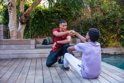 Diverse male friends by poolside embracing friendship outdoors
