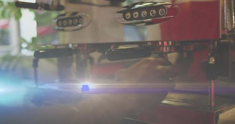 Barista inserting portafilter into espresso machine with warm backlight and lens flare