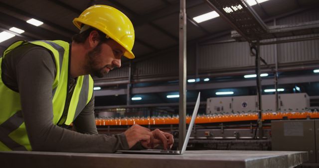 Engineer in Yellow Hard Hat Working on Laptop in Industrial Facility - Download Free Stock Images Pikwizard.com