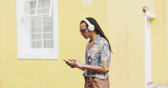 Man with headphones listening to music while walking in urban area - Download Free Stock Images Pikwizard.com