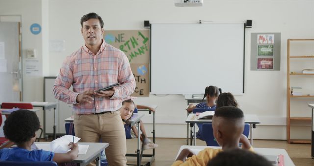 Male Teacher Using Tablet During Classroom Lesson with Diverse Students - Download Free Stock Images Pikwizard.com