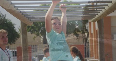 Child Playing on Monkey Bars in School Playground During Fitness Activity