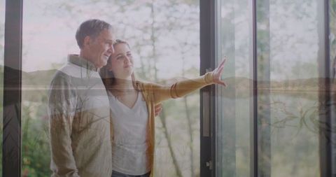 Granddaughter Sharing Warm Moment with Grandpa by Glass Door