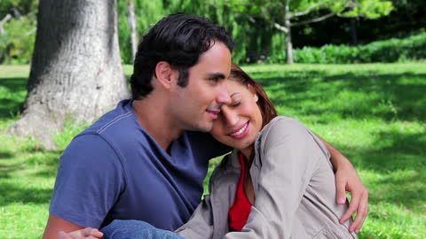Smiling Couple Embracing in Sunny Park Setting