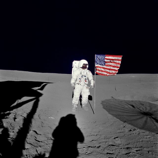 Classic landmark moment in space exploration, astronaut standing next to the American flag on moon during Apollo 14 mission. Ideal for educational materials, space exploration documentaries, historical archives, and patriotic displays.