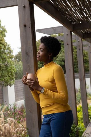 Woman holding mug in garden escape