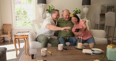 Asian family celebrates senior's birthday with joyful selfie