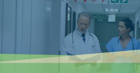 Doctors Discussing Patient Files in Hospital Corridor