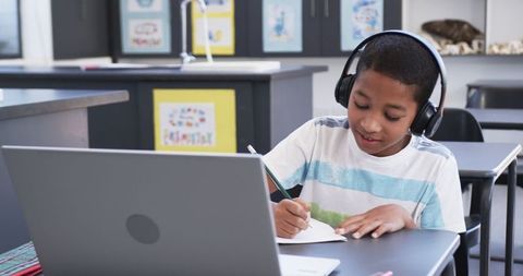 Young Student with Headphones Focused on Online Learning in Classroom - Download Free Stock Images Pikwizard.com