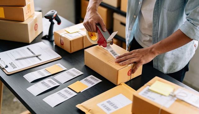 Small Business Shipping Workflow: Person Sealing Box with Tape Dispenser, Barcode Labels