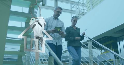 Key-shaped Embellishment Over Colleagues Walking Down Office Stairs