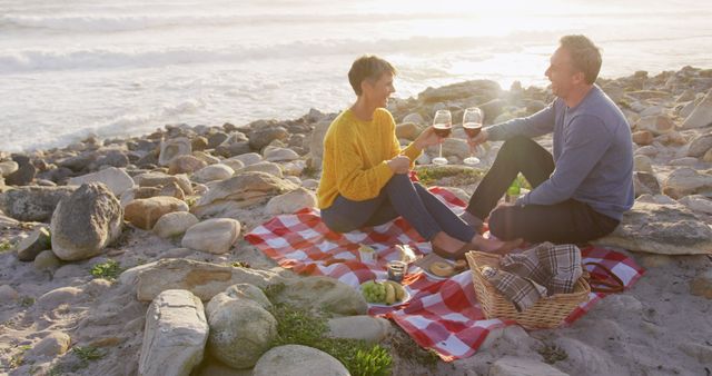 Romantic Couple Enjoying Sunset Picnic on Rocky Beach - Download Free Stock Images Pikwizard.com