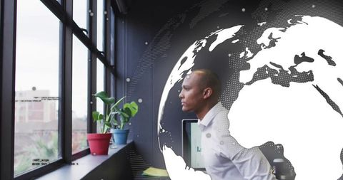 Businessman in modern office with futuristic globe graphics