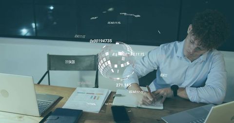 Writing professional leaning over notebook with holographic data globe and laptops