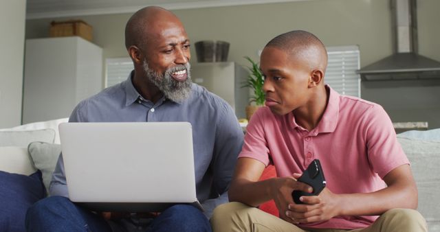 Father and Son Using Laptop and Smartphone at Home - Download Free Stock Images Pikwizard.com