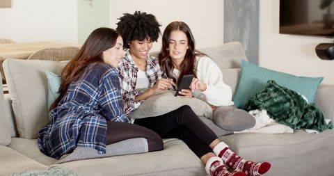 Diverse Friends Enjoying Moment Bonding Over Smartphone