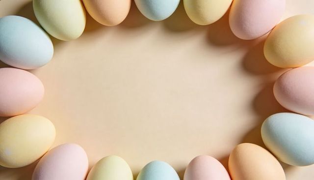 Arranging pastel easter eggs into oval frame around blank space for spring greeting cards