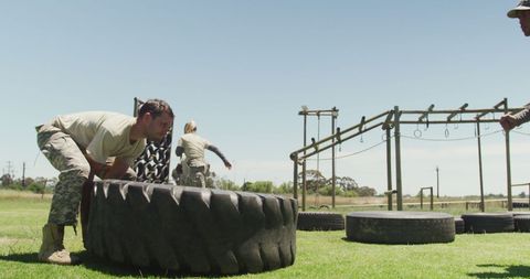 Male Soldier Training on Obstacle Course with Tire Flipping