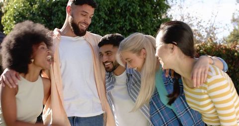 Diverse Friends Laughing and Bonding Outdoors Under Sunlight