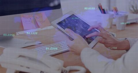 Businesswoman tapping tablet at modern desk with data overlay and analytics grid display