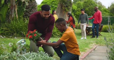 Family Planting Together While Bonding in Garden Outdoors