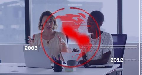 Businesswomen Collaborating at Desk with Laptop and Futuristic Red HUD Overlay