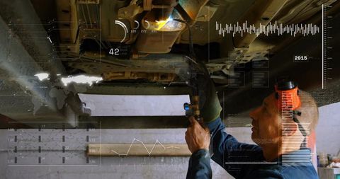 Automotive mechanic performing underbody repair with augmented hud diagnostics and tools