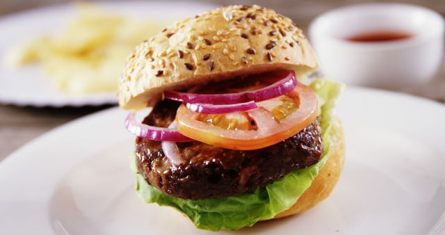 A juicy hamburger with lettuce, tomato, onions, and bacon sits ready to be enjoyed, with copy space. Its appetizing presentation invites a savory experience for those craving a classic American meal.