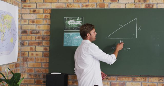 Portrait of caucasian male teacher teaching mathematics in the classroom at school. distance learning online education