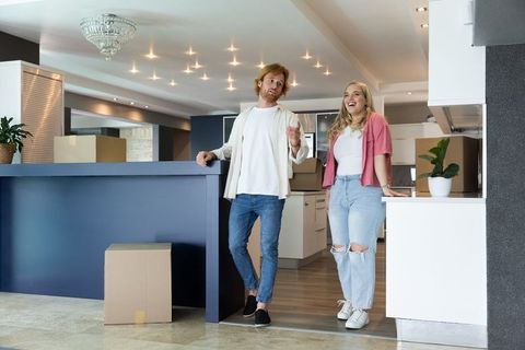 Couple Discussing Plans in Modern Kitchen Amid Moving Boxes