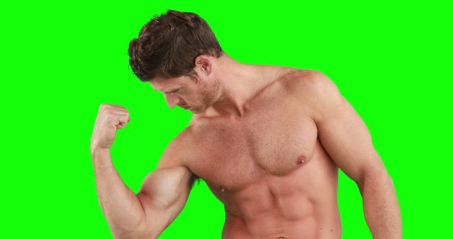 Portrait of focused caucasian strong man flexing muscles with copy space on green screen. Strength and fitness concept.