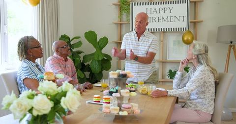 Senior friends enjoying retirement celebration with sweets and drinks